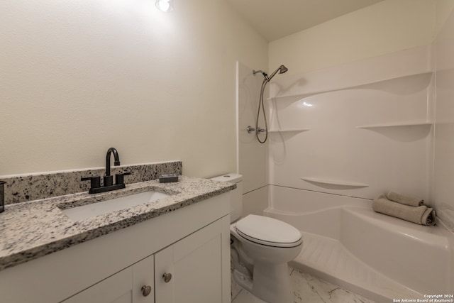 bathroom featuring vanity, walk in shower, and toilet