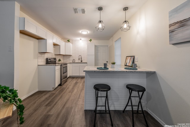 kitchen with kitchen peninsula, white cabinets, stainless steel range with electric cooktop, backsplash, and dark wood-type flooring