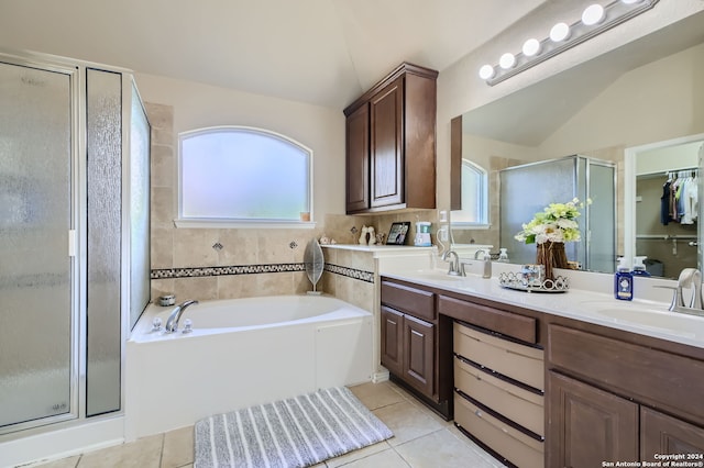 bathroom featuring vanity, lofted ceiling, shower with separate bathtub, and tile patterned flooring