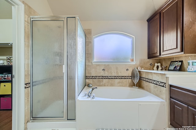 bathroom with vanity and shower with separate bathtub