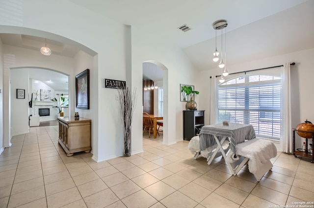 dining area with light tile patterned floors and vaulted ceiling