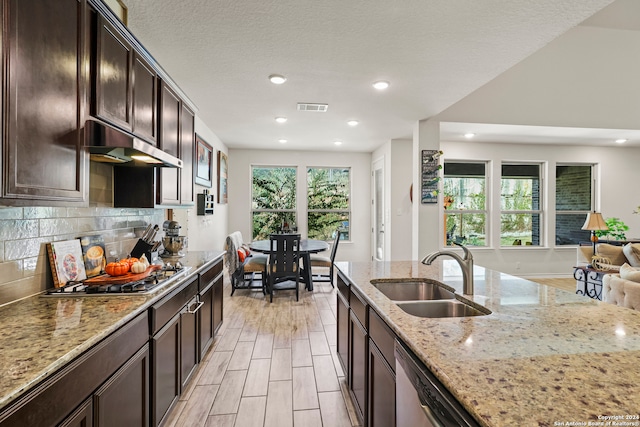 kitchen featuring a wealth of natural light, sink, appliances with stainless steel finishes, and light stone countertops