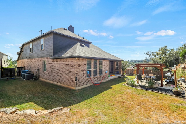 rear view of property featuring a pergola, a patio area, and a yard