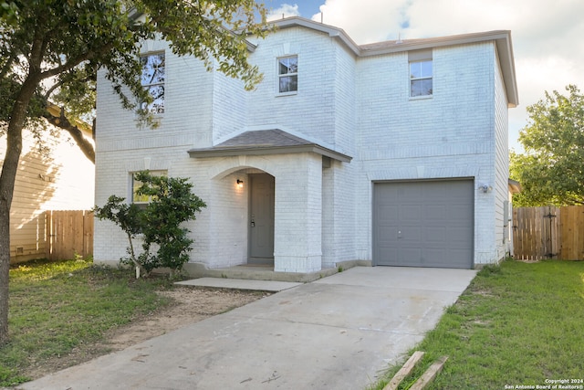 view of front of property featuring a front yard and a garage