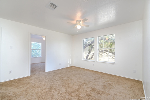 unfurnished room with light carpet, a textured ceiling, and ceiling fan