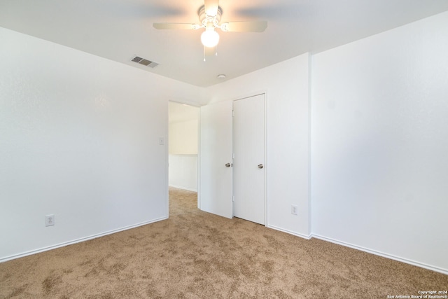 carpeted spare room featuring ceiling fan