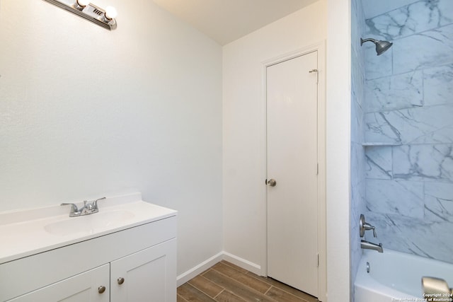 bathroom with tiled shower / bath, vanity, and hardwood / wood-style floors