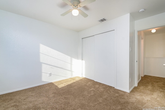 unfurnished bedroom with carpet flooring, a closet, and ceiling fan