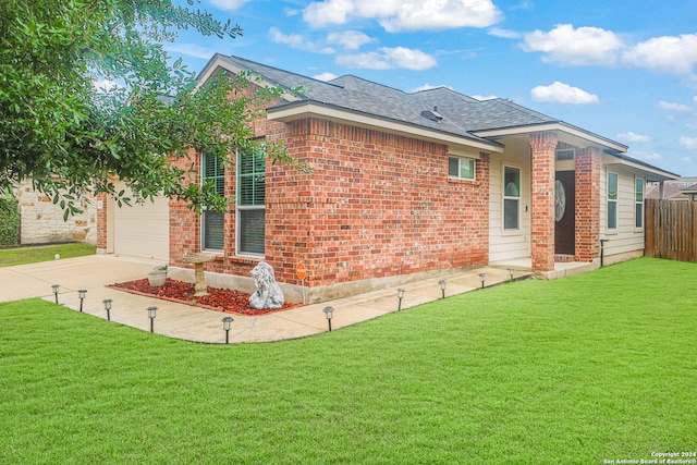 exterior space featuring a garage and a lawn