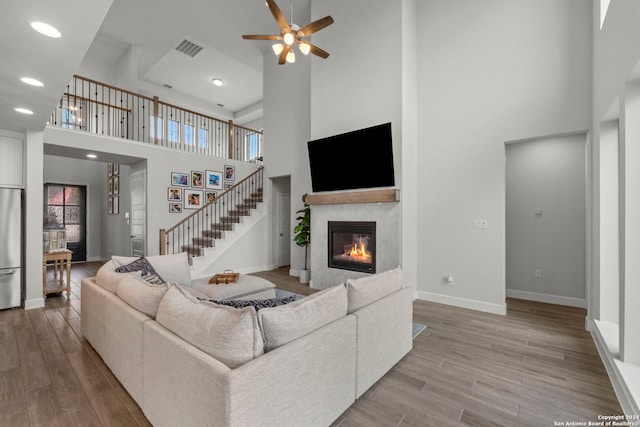 24054 Sidehill Lie, San Antonio, TX 78261 - living room featuring a high ceiling, a glass covered fireplace, ceiling fan, baseboards, and plenty of natural light