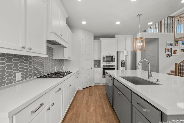 24054 Sidehill Lie, San Antonio, TX 78261 - kitchen with stainless steel appliances, a sink, a kitchen island with sink, light countertops, and white cabinetry