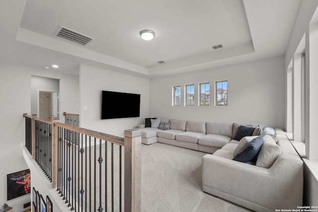 carpeted living room with a raised ceiling