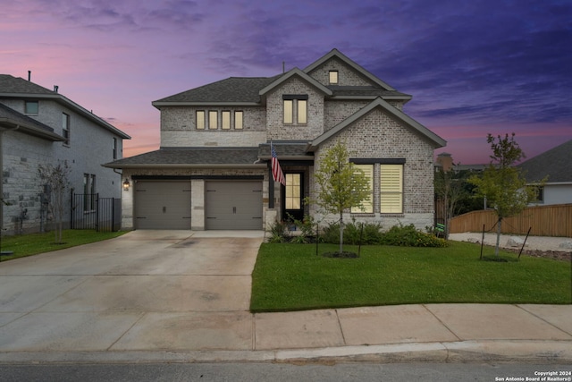 view of front of house with a garage and a lawn