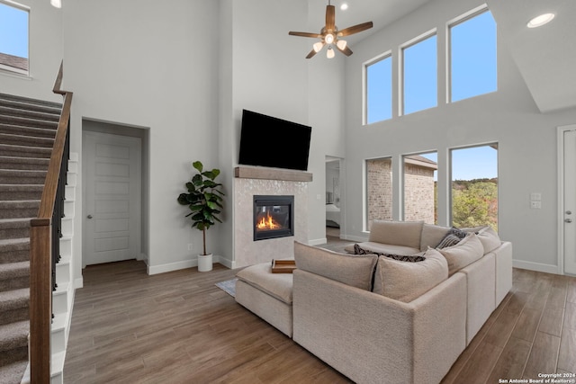 24054 Sidehill Lie, San Antonio, TX 78261 - living area featuring a towering ceiling, stairs, wood finished floors, a tiled fireplace, and a ceiling fan