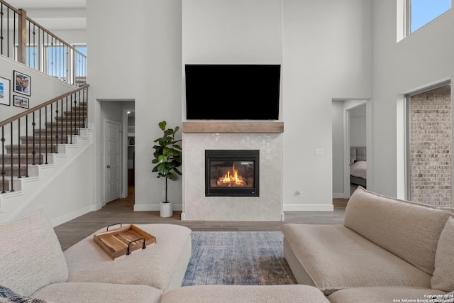 24054 Sidehill Lie, San Antonio, TX 78261 - living room featuring a high ceiling, wood finished floors, baseboards, a premium fireplace, and stairs