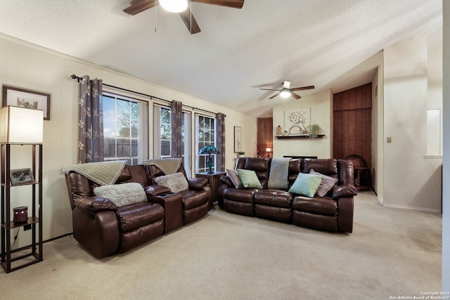 carpeted living room with ceiling fan, a textured ceiling, and lofted ceiling