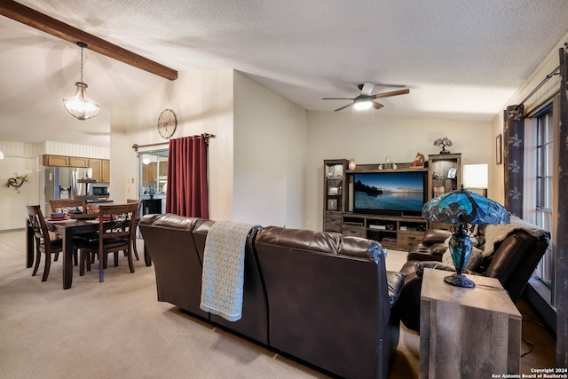 carpeted living room with ceiling fan, a textured ceiling, and vaulted ceiling with beams