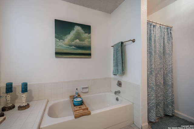 bathroom featuring a textured ceiling and shower with separate bathtub