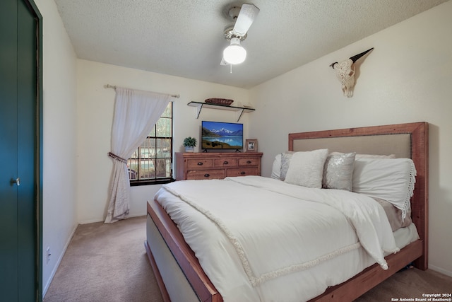 bedroom with a textured ceiling, carpet flooring, and ceiling fan