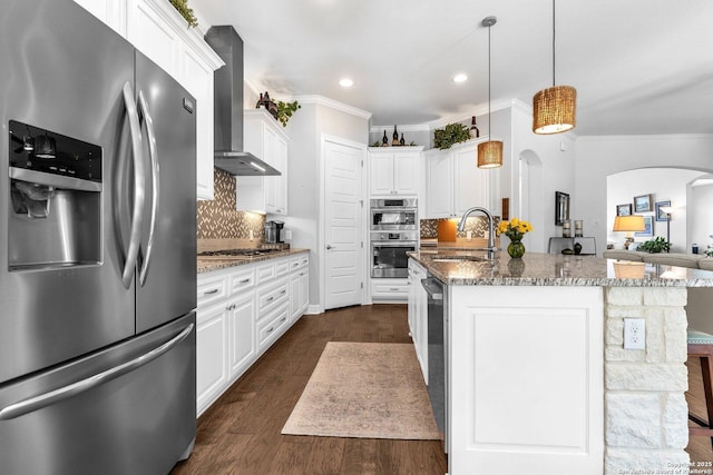 kitchen featuring wall chimney exhaust hood, white cabinetry, stainless steel appliances, and sink