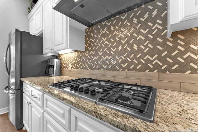 kitchen featuring white cabinetry, tasteful backsplash, stainless steel appliances, and wall chimney exhaust hood