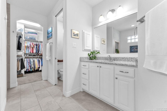 bathroom with vanity, toilet, and tile patterned flooring