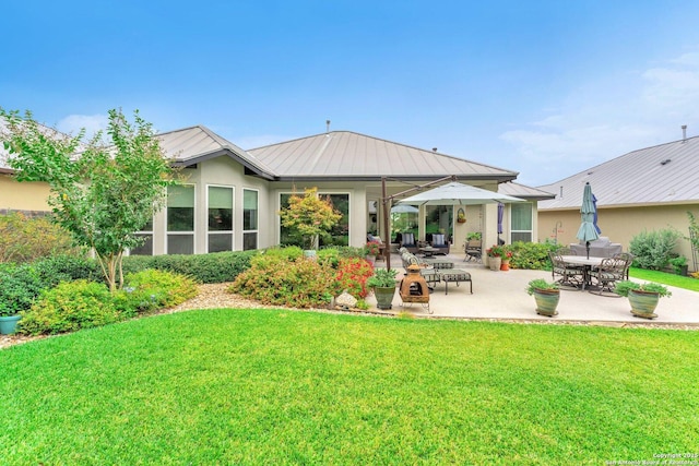 back of property featuring a patio and a lawn