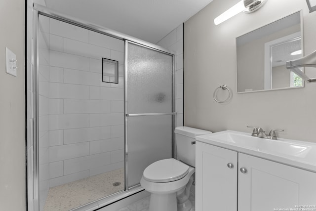 bathroom with vanity, a shower with shower door, and toilet