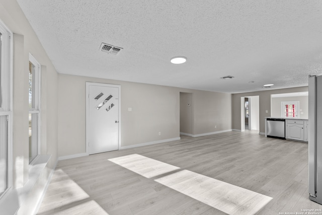 unfurnished living room featuring light hardwood / wood-style flooring and a textured ceiling