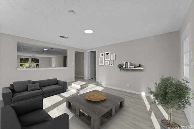 living room with light hardwood / wood-style floors and a textured ceiling