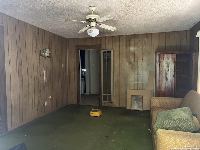 627 Canton, San Antonio, TX 78202 - living area with wooden walls, ceiling fan, a textured ceiling, and carpet floors