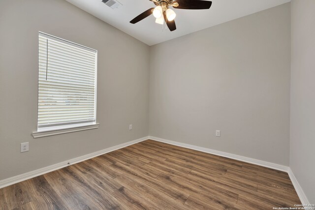 spare room featuring ceiling fan, plenty of natural light, and dark hardwood / wood-style floors