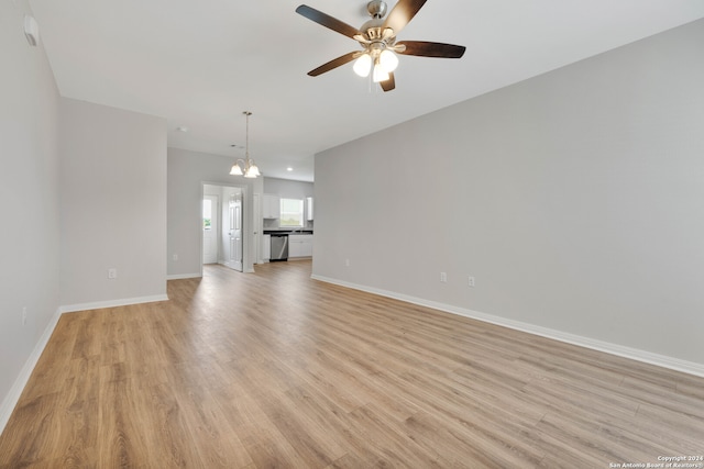 unfurnished living room featuring light hardwood / wood-style flooring and ceiling fan with notable chandelier