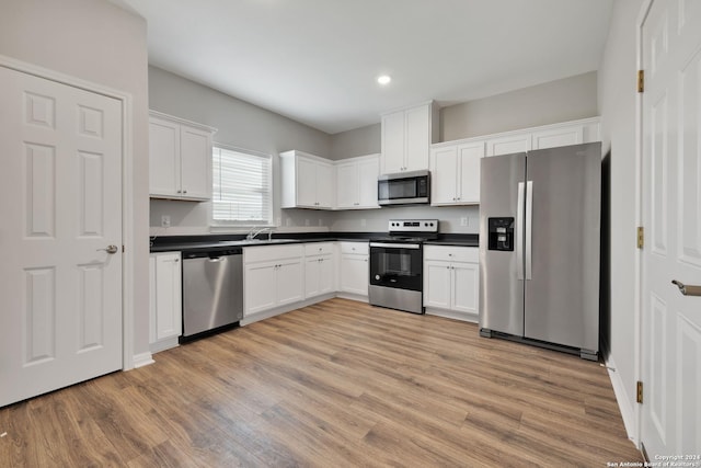518 Precious Dr, San Antonio, TX 78237 - kitchen featuring light wood-style flooring, white cabinetry, appliances with stainless steel finishes, and dark countertops
