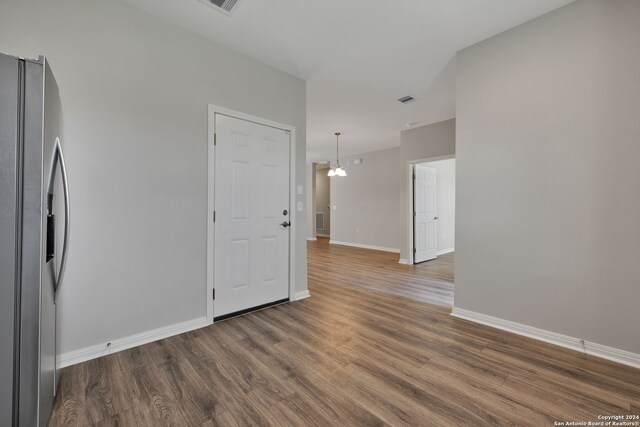 empty room featuring a notable chandelier and dark hardwood / wood-style floors