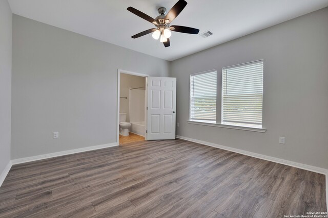 unfurnished bedroom featuring connected bathroom, ceiling fan, and wood-type flooring