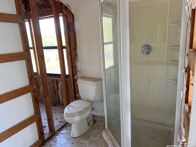 bathroom featuring toilet and an enclosed shower