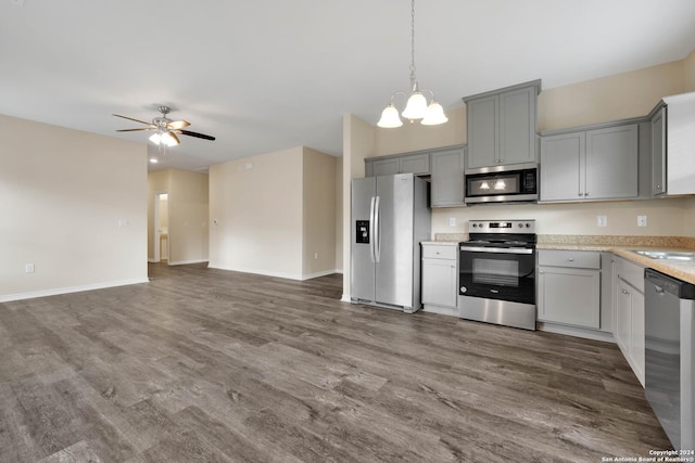 kitchen featuring stainless steel appliances, ceiling fan with notable chandelier, open floor plan, light countertops, and gray cabinets