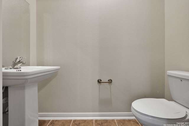 bathroom featuring sink, toilet, and tile patterned flooring