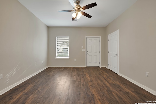 empty room featuring ceiling fan and dark hardwood / wood-style flooring