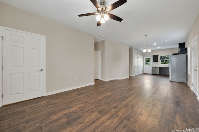 unfurnished living room with dark hardwood / wood-style floors and ceiling fan with notable chandelier