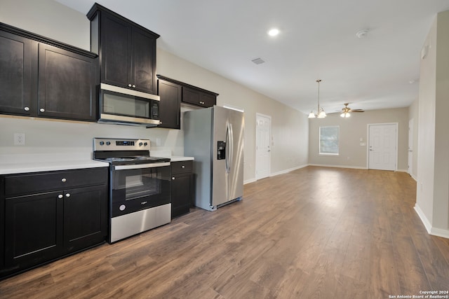 kitchen with pendant lighting, appliances with stainless steel finishes, wood-type flooring, and ceiling fan with notable chandelier