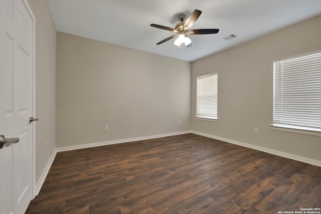 empty room with ceiling fan and dark hardwood / wood-style flooring