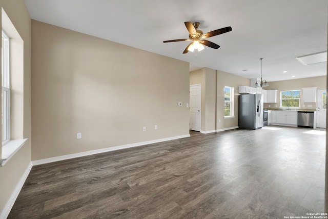 unfurnished living room featuring dark hardwood / wood-style floors and ceiling fan with notable chandelier