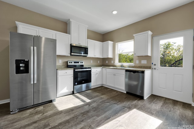 kitchen featuring white cabinetry, stainless steel appliances, dark hardwood / wood-style flooring, and sink