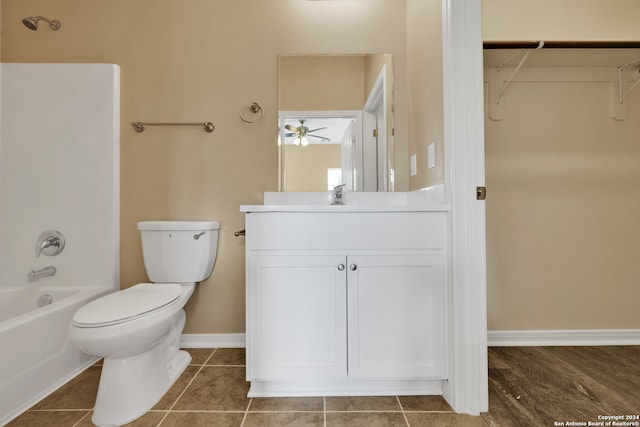 full bathroom with hardwood / wood-style floors, ceiling fan, toilet, vanity, and bathing tub / shower combination