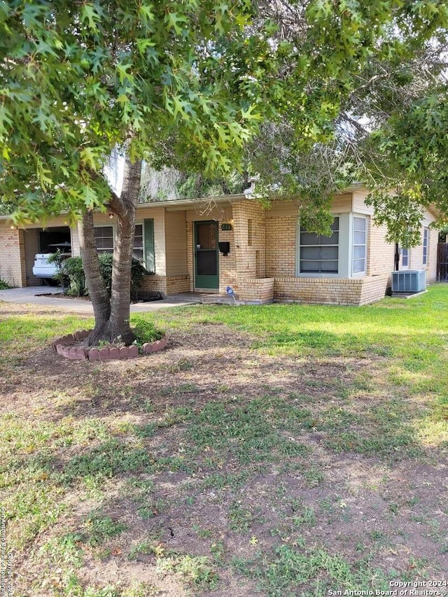 view of front of home with a front lawn and central AC unit