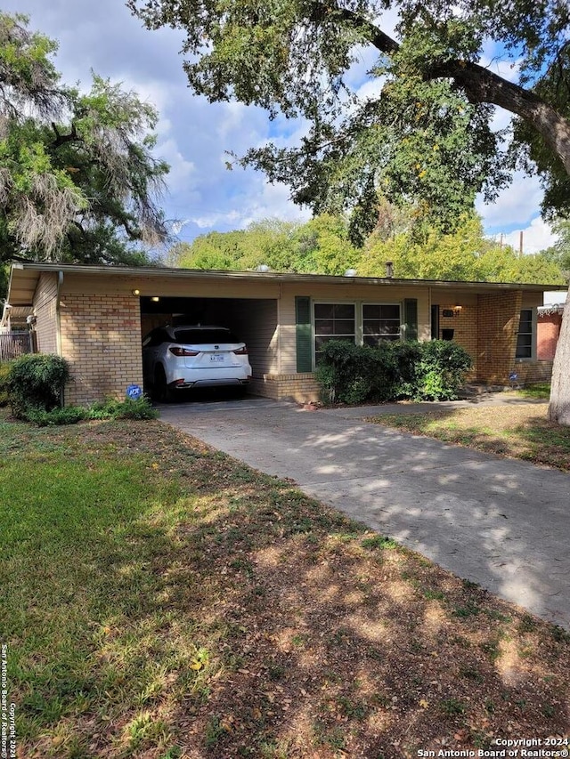 ranch-style house featuring a carport and a front lawn