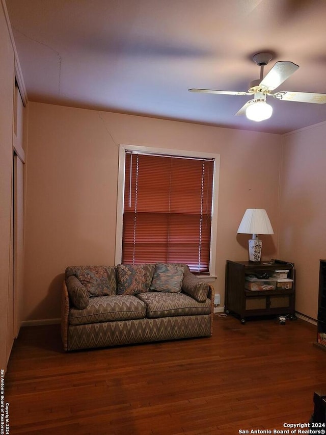 living room with dark wood-type flooring and ceiling fan