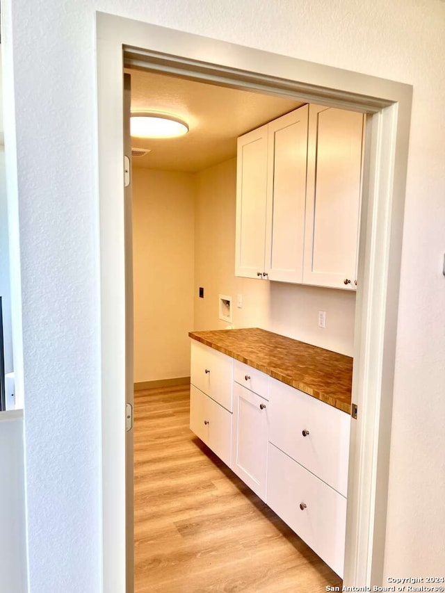 kitchen featuring light hardwood / wood-style floors, wood counters, and white cabinets